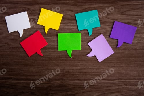 Preview: Colorful speech bubbles representing diverse opinions and ideas on wooden background