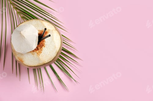 Preview: Fresh green coconut with drinking straws and palm leaf on color background
