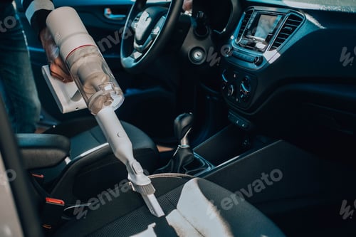 Preview: Close-up of a man vacuuming a car seat.