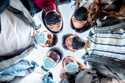 Preview: Multiracial friends together in a circle wearing face masks
