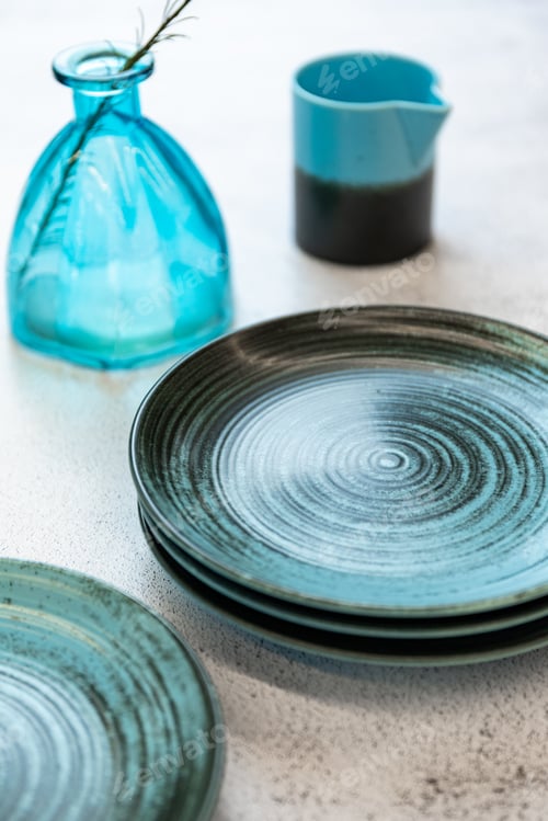 Preview: Ceramic set of blue empty kitchen plates on a white marble background. Eco and minimal tableware.