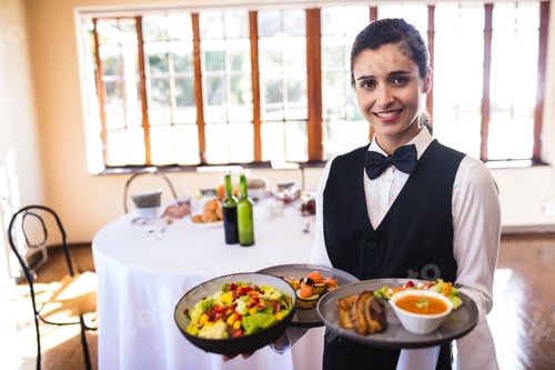 Preview: Female server holding trays laden with salad soup bread appetizers in banquet hall, copy space