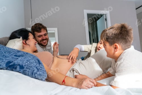 Preview: Happy Caucasian family of father, pregnant mother and their two children
