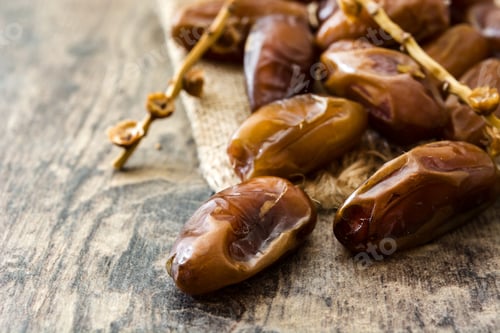 Preview: Fresh medjool dates resting on rustic wooden table