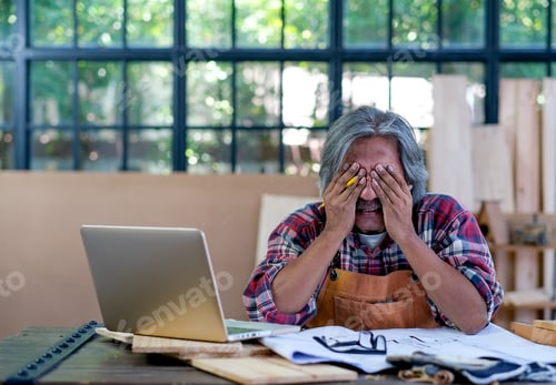 Preview: Senior Asian craftsman act as feel bad or sad with something appear on laptop