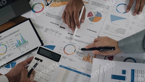 Preview: Business People Meeting using laptop computer,calculator,notebook,stock market chart paper for