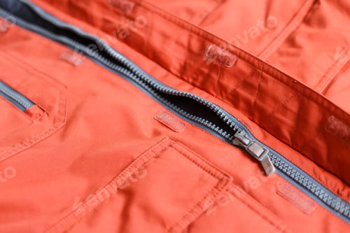 Preview: Part of a zipper with a lock on red cloth