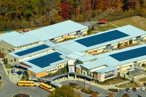 Preview: Aerial view of american school building with rooftop covered with photovoltaic solar panels