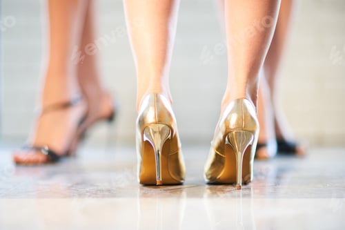 Preview: Close-up of women's feet in gold-colored shoes .