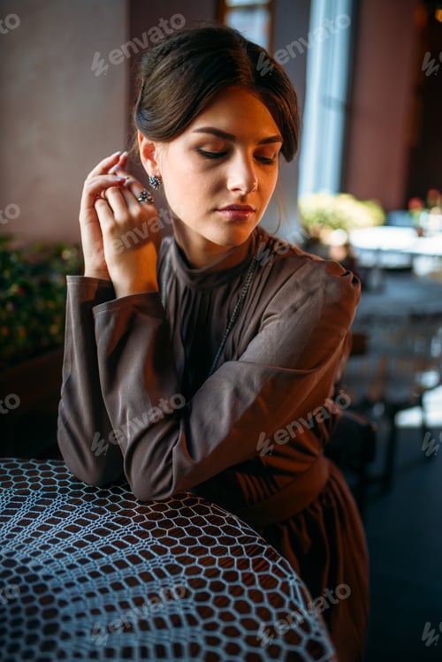 Preview: Adorable dark-haired girl sitting in cafe