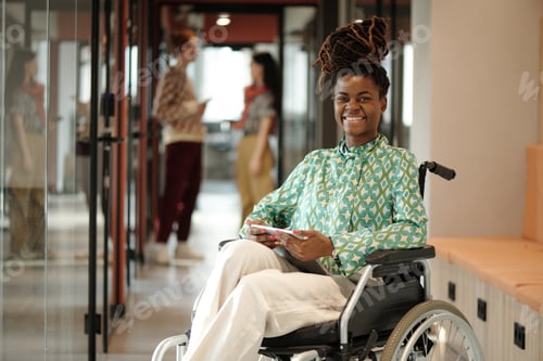 Preview: Portrait of Young Adult Black Woman Smiling While Working in Creative Coworking