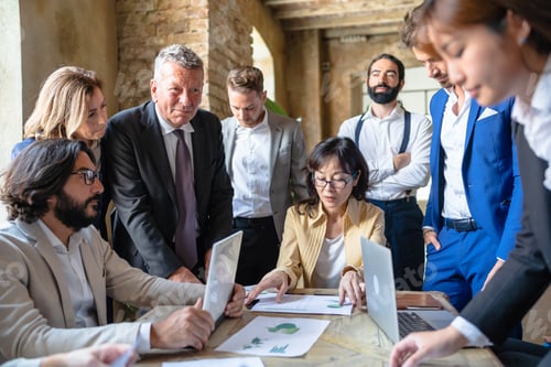 Preview: Business people sitting at the conference table while discussing about sustainable innovation