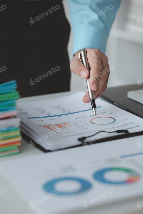 Preview: A business finance man is reviewing a company's financial documents prepared by the Finance Departme