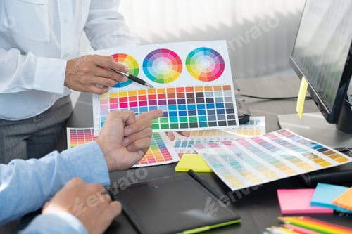 Preview: graphic designer team working on web design using color swatches editing artwork using tablet and a