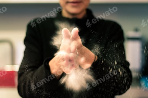 Preview: Woman clapping her hands to spread flour