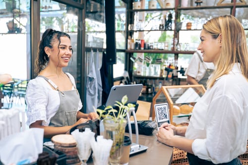Preview: Caucasian attractive women receive coffee from waiter in coffee house.