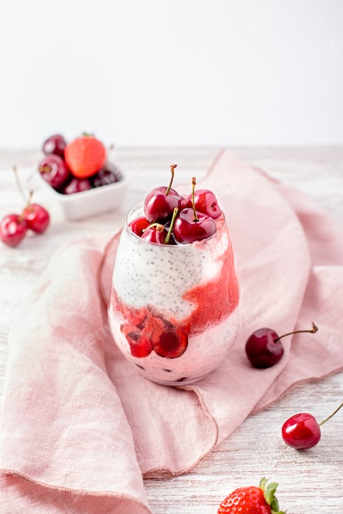 Preview: Chia seeds, cherry and strawberry layered pudding in glasses on table