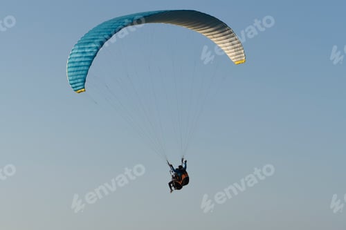 Preview: Beautiful shot of a skydiver flying during sunset with mountains