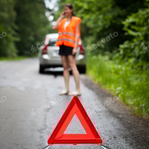 Preview: Young female driver wearing a high visibility vest, calling the