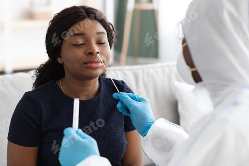 Preview: Doctor in protective suit takes swab to patient at home