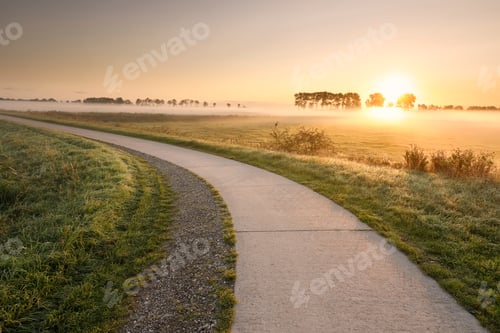 Preview: cycling road in countryside at misty sunrise