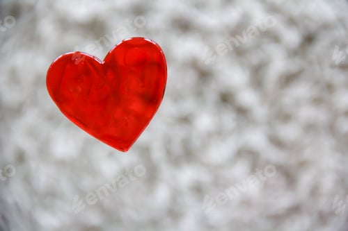 Preview: Red mockup friendly heart on glass surface and blurry textured light background with copy space