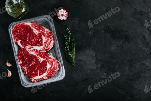 Preview: Ground Beef steak in vacuum packaging with seasonings on dark stone background
