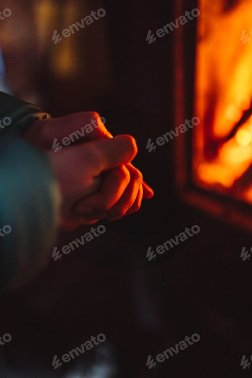 Preview: Woman warming up near a fireplace in a hut