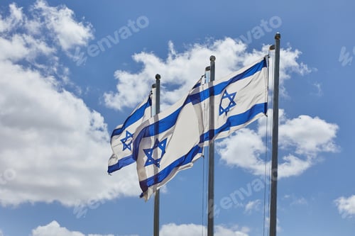Preview: Four Israeli flags proudly waving under the blue sky with hills in the background