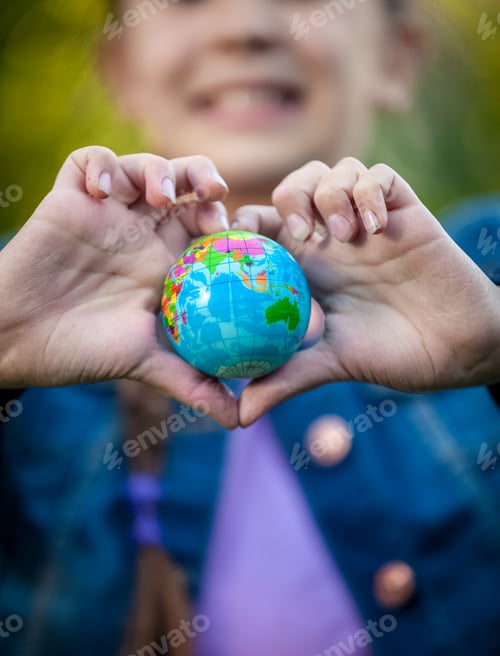 Preview: smiling girl holding globe in hands folded in shape of heart