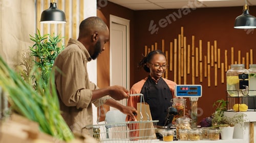 Preview: Client giving produce to vendor to weight on local market scale