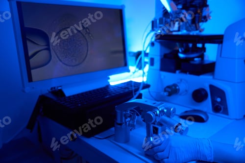 Preview: Embryologist carrying out intracytoplasmic sperm injection displayed on monitor