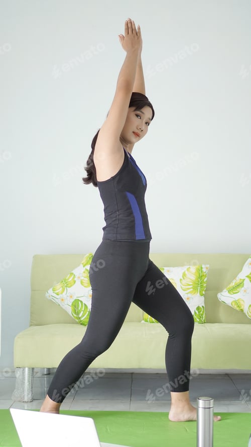 Preview: asian woman practicing yoga at home doing hand warm up