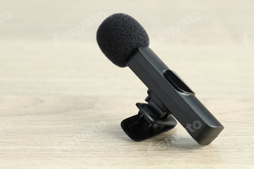 Preview: Lavalier microphone on wooden table, closeup. Audio equipment