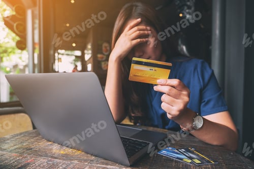 Preview: A woman get stressed and broke while holding credit card with laptop on the table