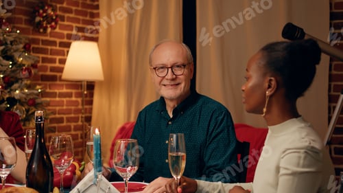 Preview: Happy senior man enjoying Christmas dinner table together with close family members