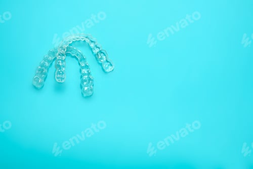 Preview: two transparent dental retainers on blue background