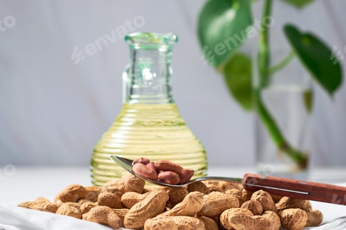 Preview: Peanut oil in glass bottle and peanuts. gourmet and medical option.