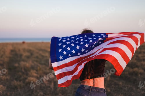 Preview: Cute teenage girl patriot of America with American flag in golden hour. Independence Day, 4 July. N