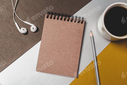 Preview: Notebook, pencil, cup of coffee, and earphones on a table in a workspace setting