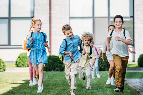 Preview: group of happy pupils runing by school garden