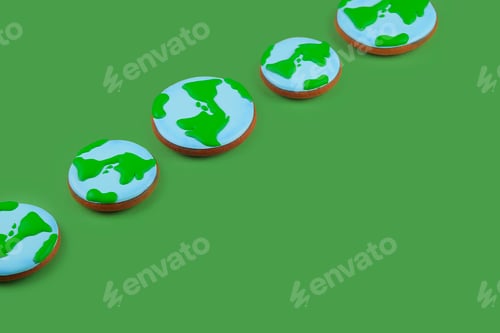 Preview: Earth Day concept. Сookies in shape of Earth on green backdrop.