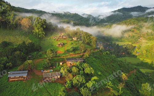 Preview: Aerial view from drone of the rural village in the mountains on foggy day