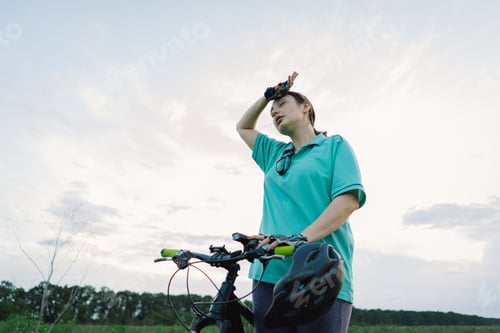 Preview: Woman Cyclist Pauses to Rest in Countryside