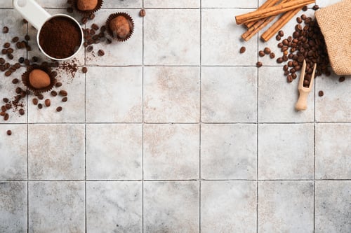 Preview: Coffee background. Measuring spoons with ground coffee, beans, cup and sweet chocolate truffles on o