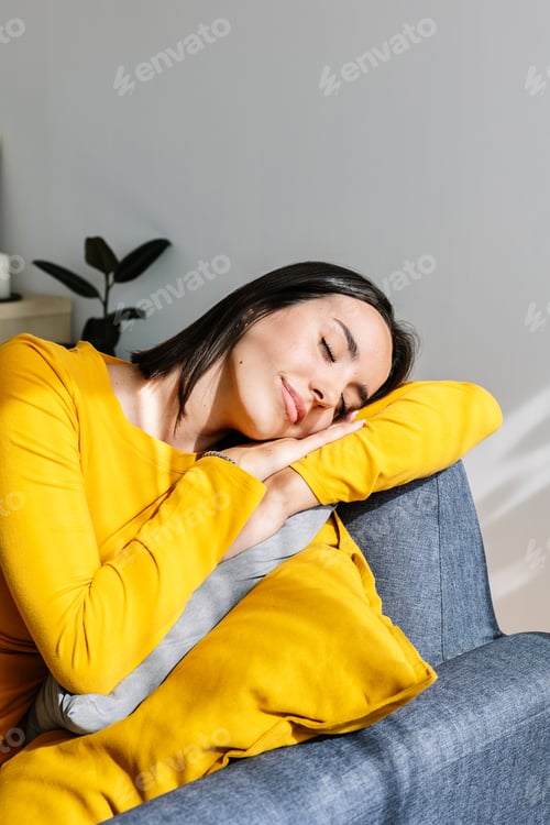 Preview: Young beautiful woman relaxing on sofa at home.