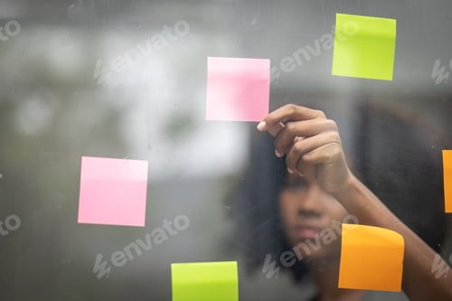 Preview: A black American african business woman in afro hairstyle planning in meeting at office and use post