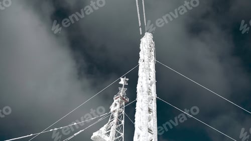 Preview: Snow-covered radio tower on background sky. Clip. Frozen structure of electric tower in winter
