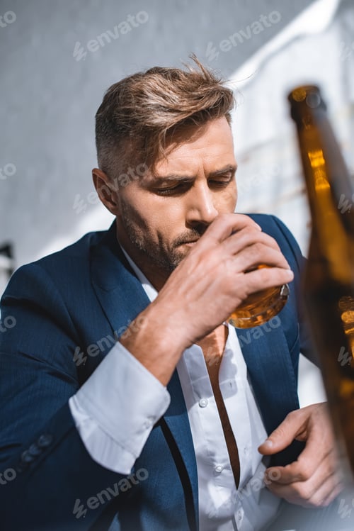 Preview: selective focus of businessman holding glass and drinking whiskey