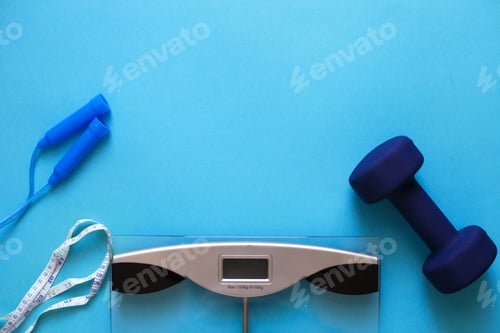 Preview: Flat lay composition with weigh scales, skipping rope and dumbbells